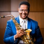 Portrait of Steven Banks holding a Saxophone.